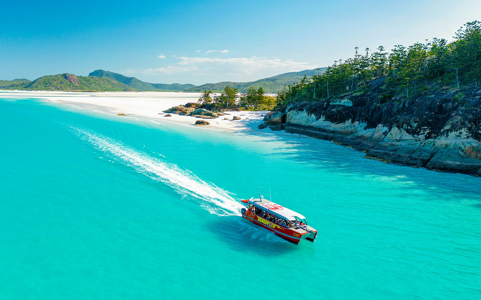 Thundercat boat cruising through turquoise waters near Whitsundays beach.