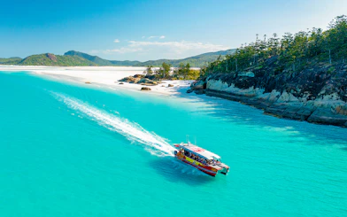 Thundercat boat cruising through turquoise waters near Whitsundays beach.