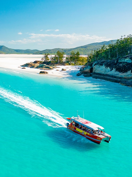 Thundercat boat cruising through turquoise waters near Whitsundays beach.