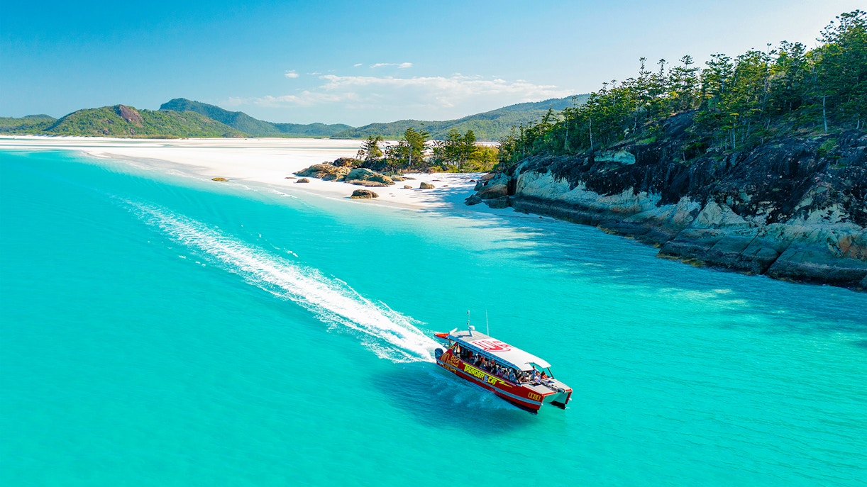 Thundercat boat cruising through turquoise waters near Whitsundays beach.