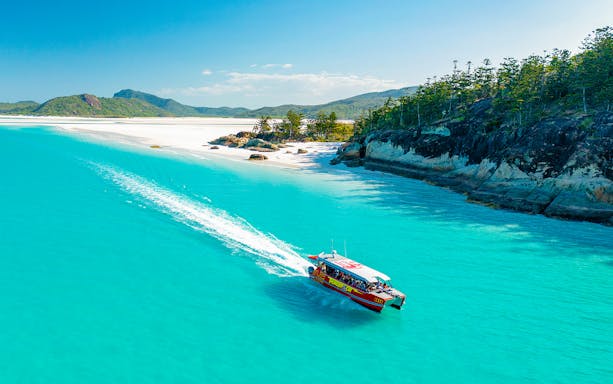 Thundercat boat cruising through turquoise waters near Whitsundays beach.