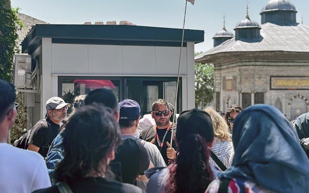 Tour guide leading a group near a historic building in Istanbul's Old City.