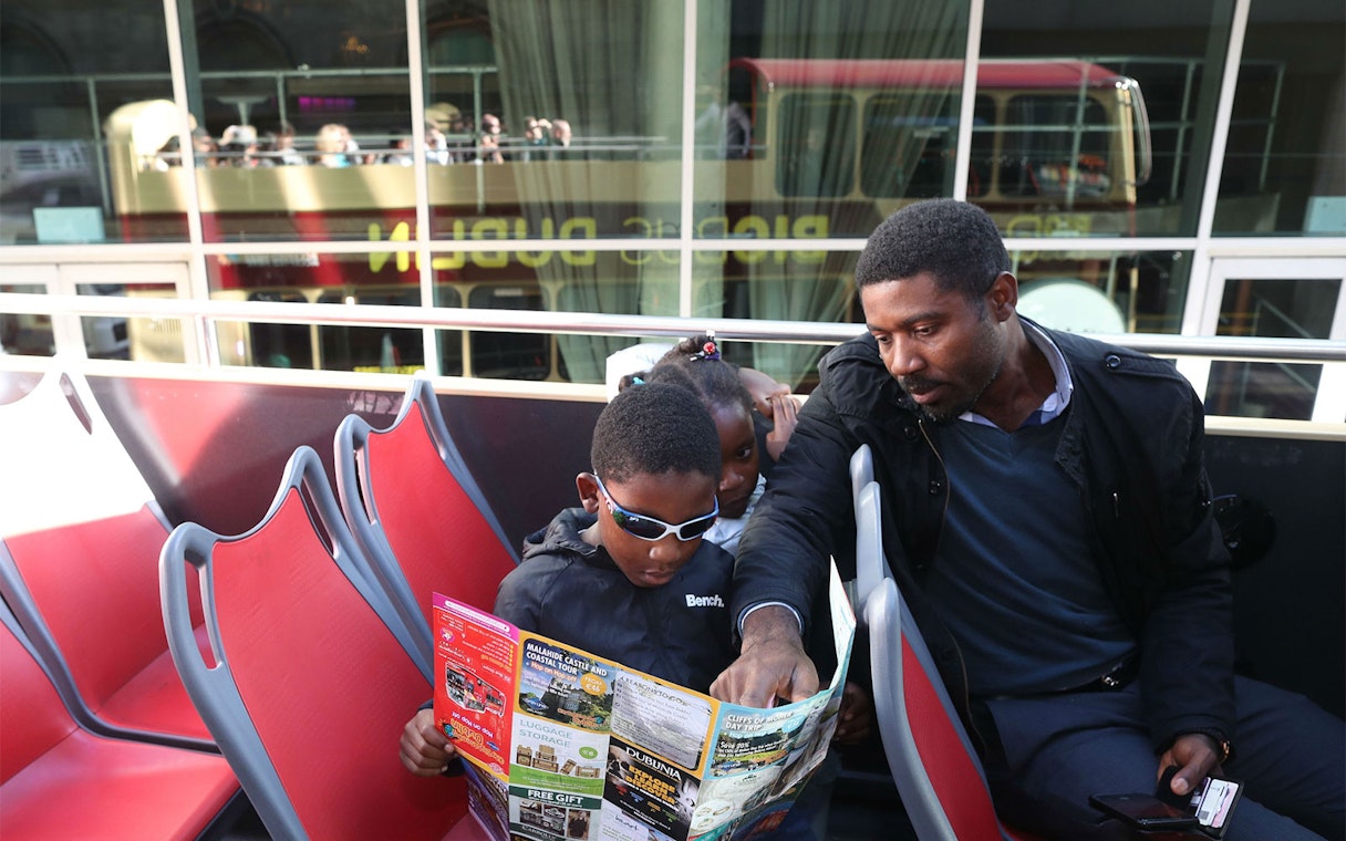 Family reading map on Dublin hop-on-hop-off bus tour.