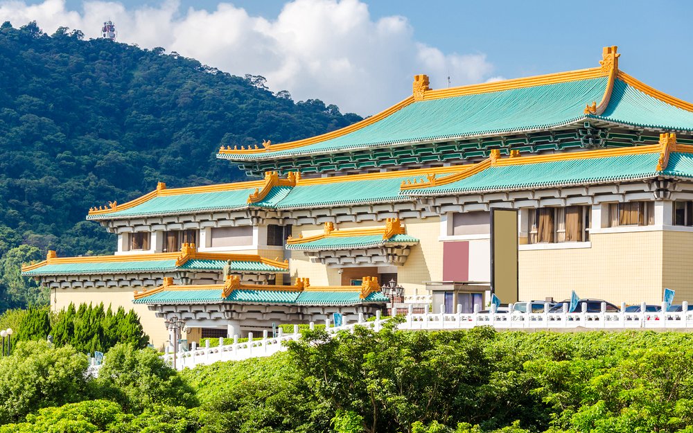 Taiwan Palace Museum exterior with green roof and mountain backdrop.