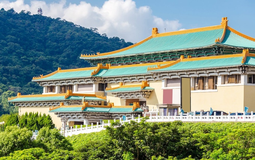 Taiwan Palace Museum exterior with green roof and mountain backdrop.