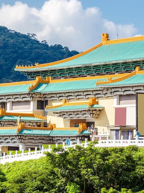 Taiwan Palace Museum exterior with green roof and mountain backdrop.