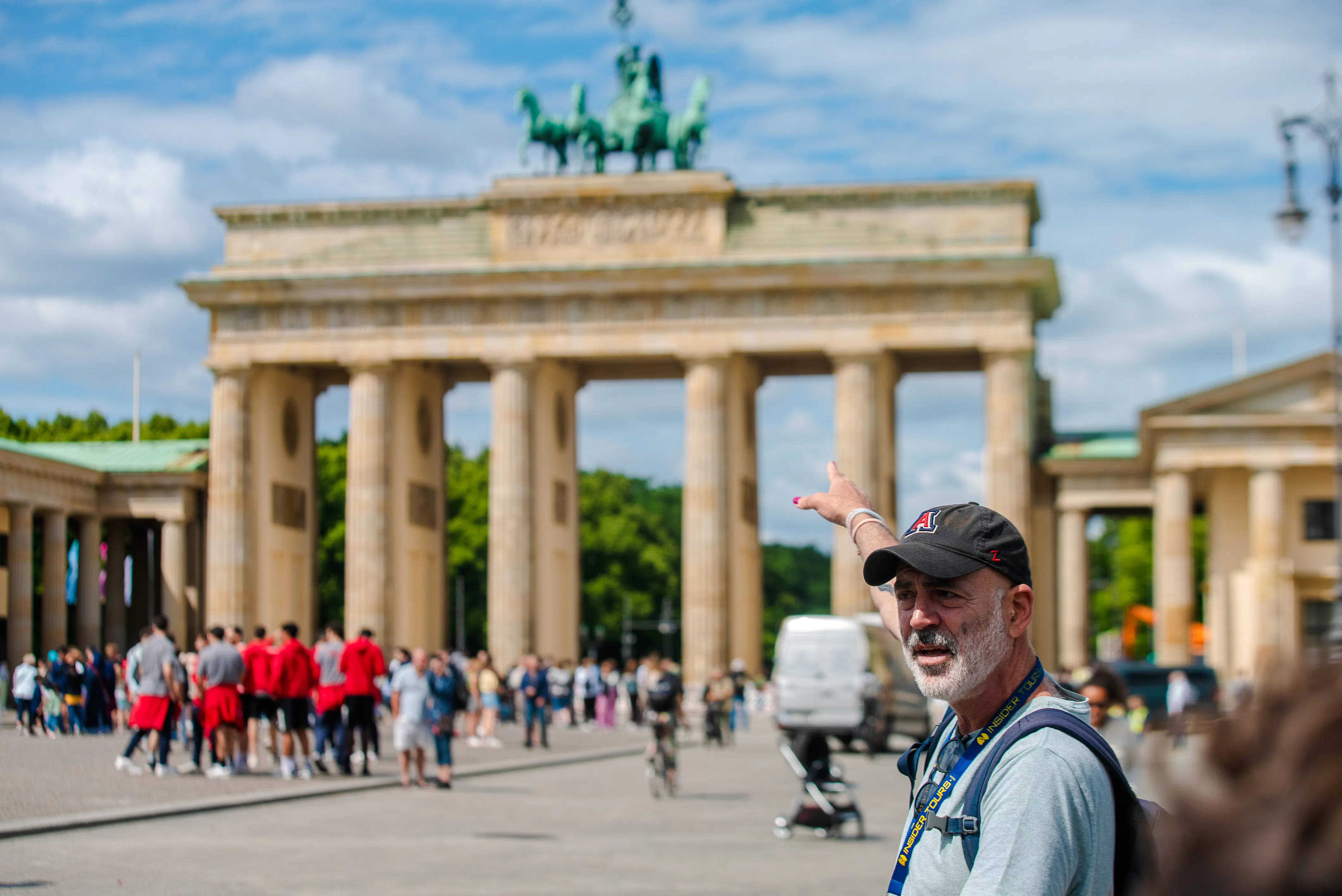 Tour guide pointing at Brandenburg Gate during Berlin walking tour.