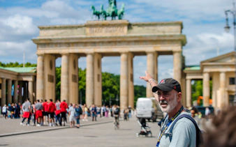 Tour guide pointing at Brandenburg Gate during Berlin walking tour.