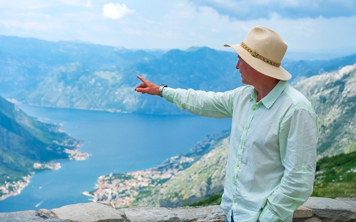 Tour guide pointing at Kotor Bay during Private Montenegro Tour.