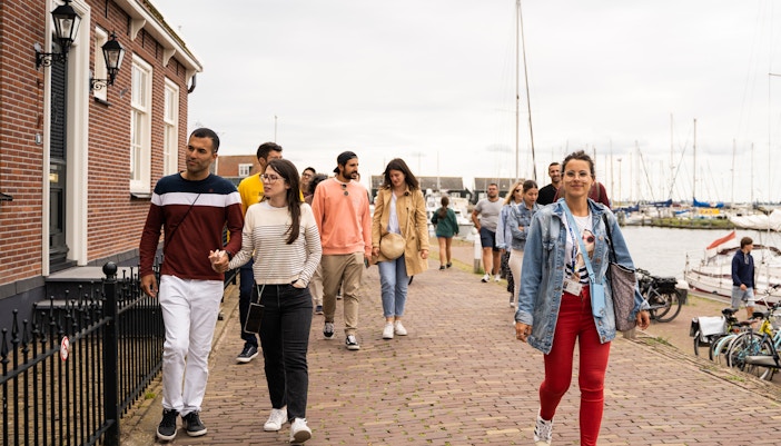 Group walking along a canal in Giethoorn village during a guided tour.