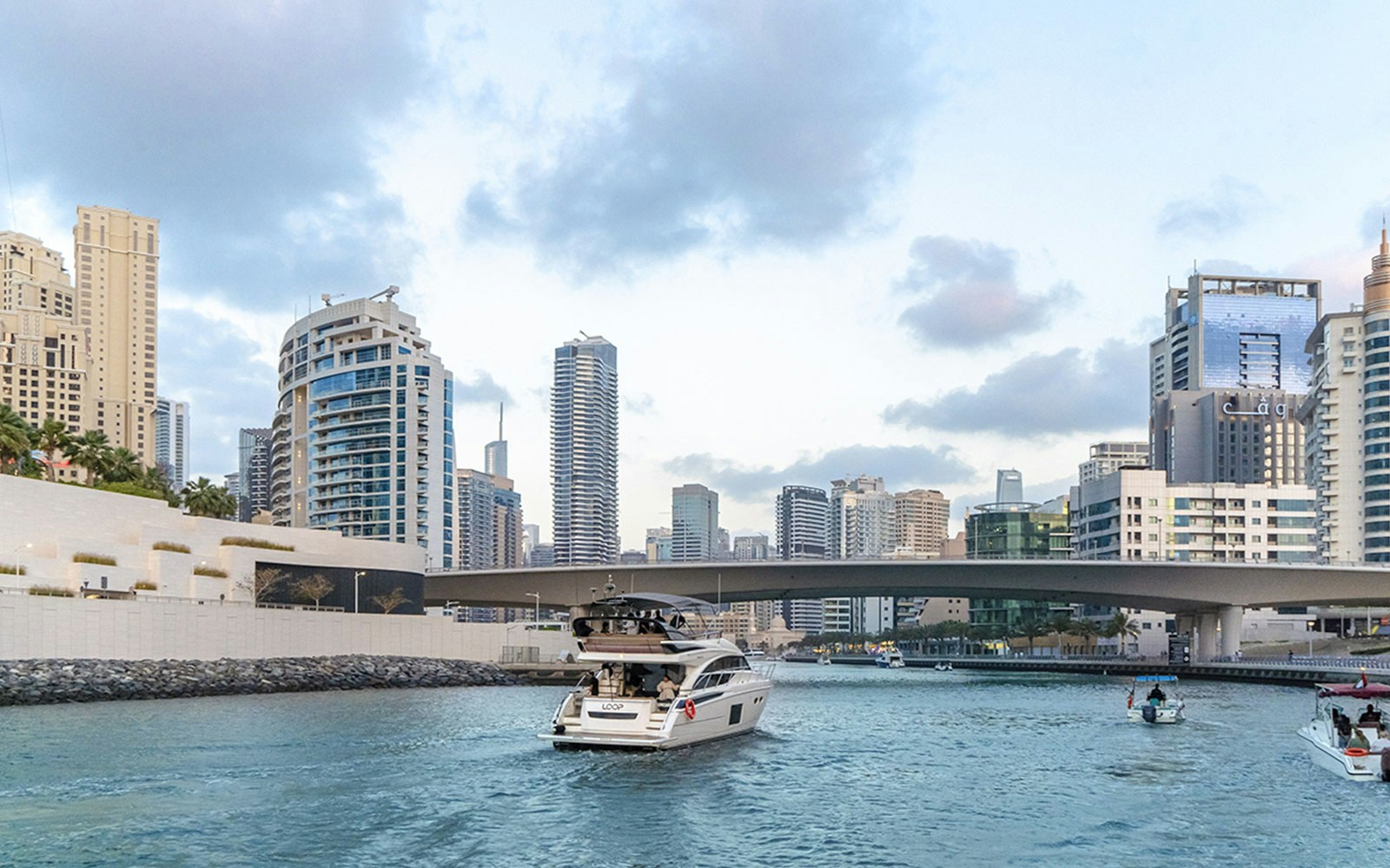 Luxury yacht cruising from Dubai Harbour with BBQ and snacks, showcasing city skyline and iconic landmarks.