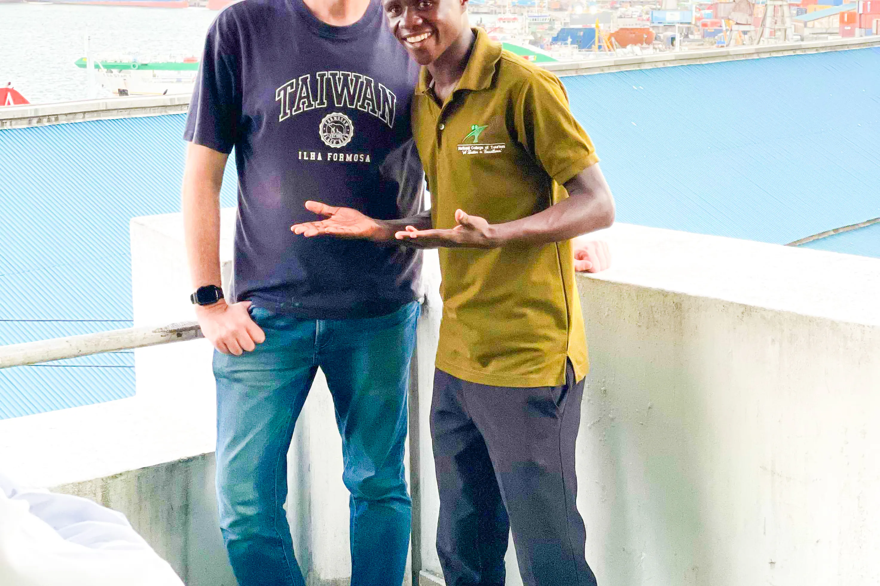 Tour guide with a visitor on Dar es Salaam Walking Tour, overlooking the harbor.