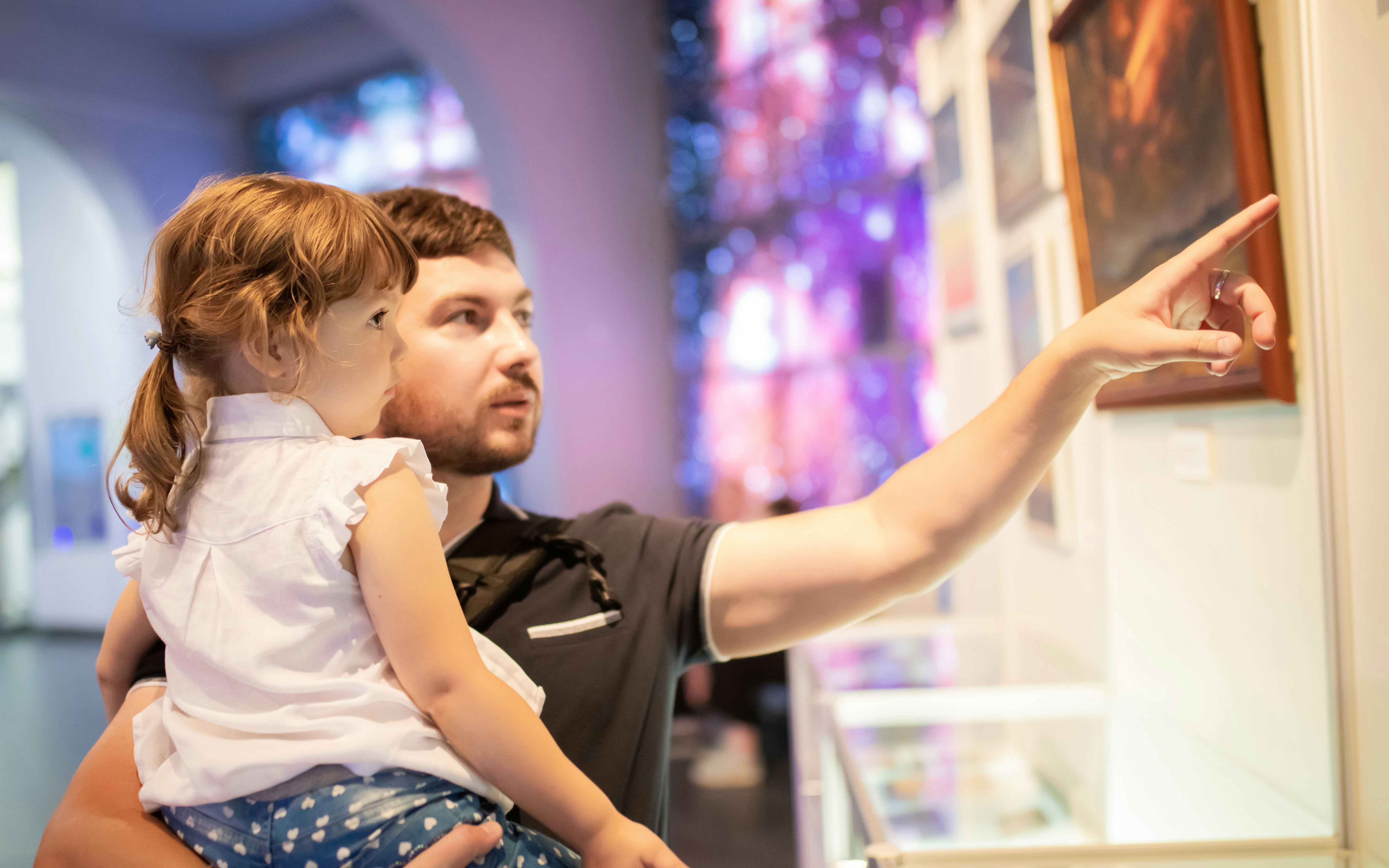 Father and child exploring exhibits at Lisbon planetarium exhibition.