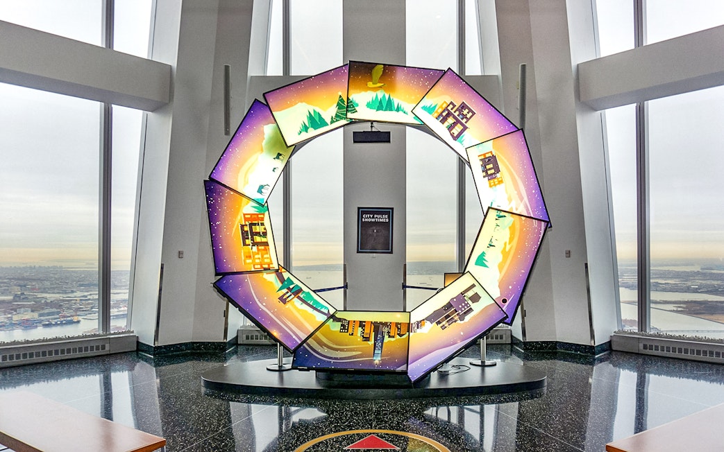 Interactive display at One World Observatory with city and nature scenes.