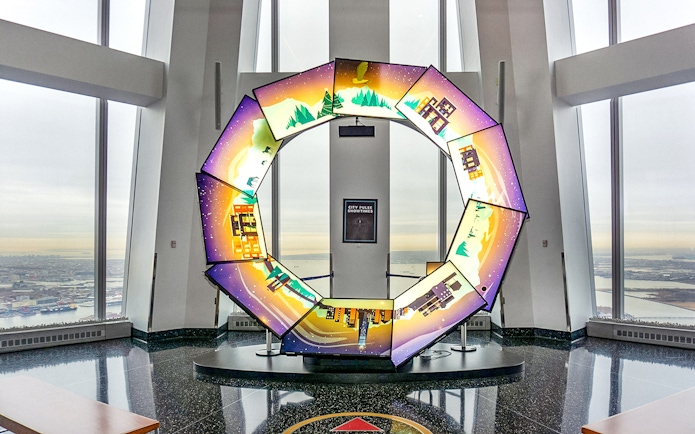 Interactive display at One World Observatory with city and nature scenes.