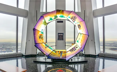 Interactive display at One World Observatory with city and nature scenes.