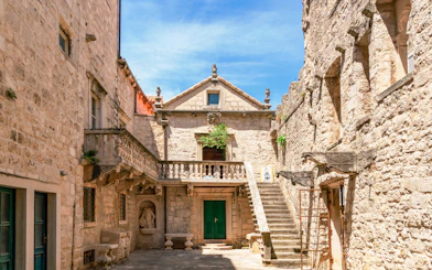 Courtyard of Marco Polo Museum in Korcula, Croatia, featuring stone architecture and staircase.