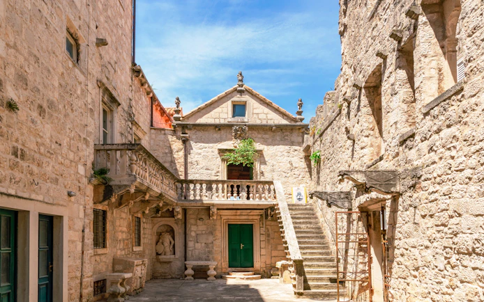 Courtyard of Marco Polo Museum in Korcula, Croatia, featuring stone architecture and staircase.