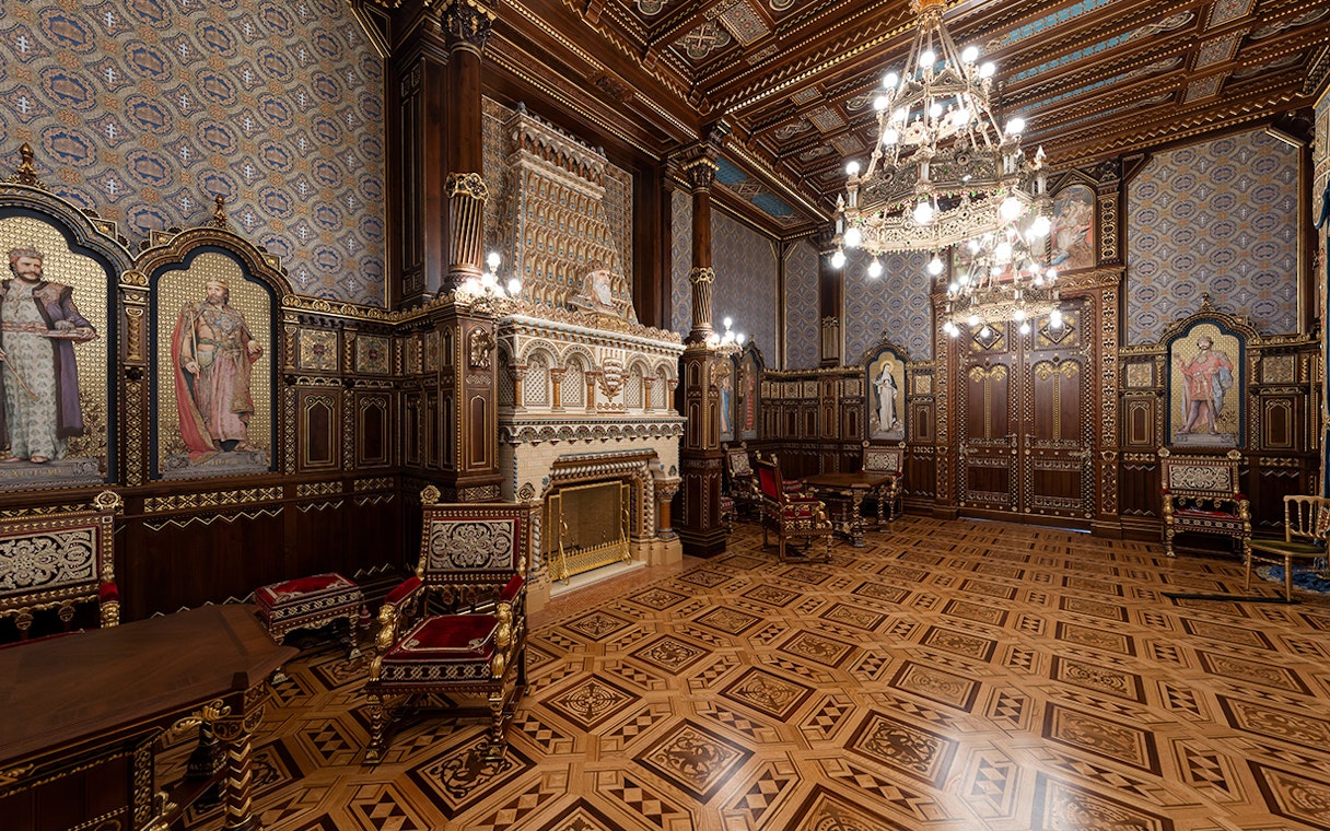 St Stephen's Hall interior with ornate woodwork, chandeliers, and historical murals.