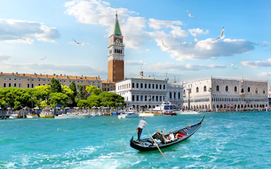 Gondola on Grand Canal with view of Doge's Palace and Bell Tower, Venice.