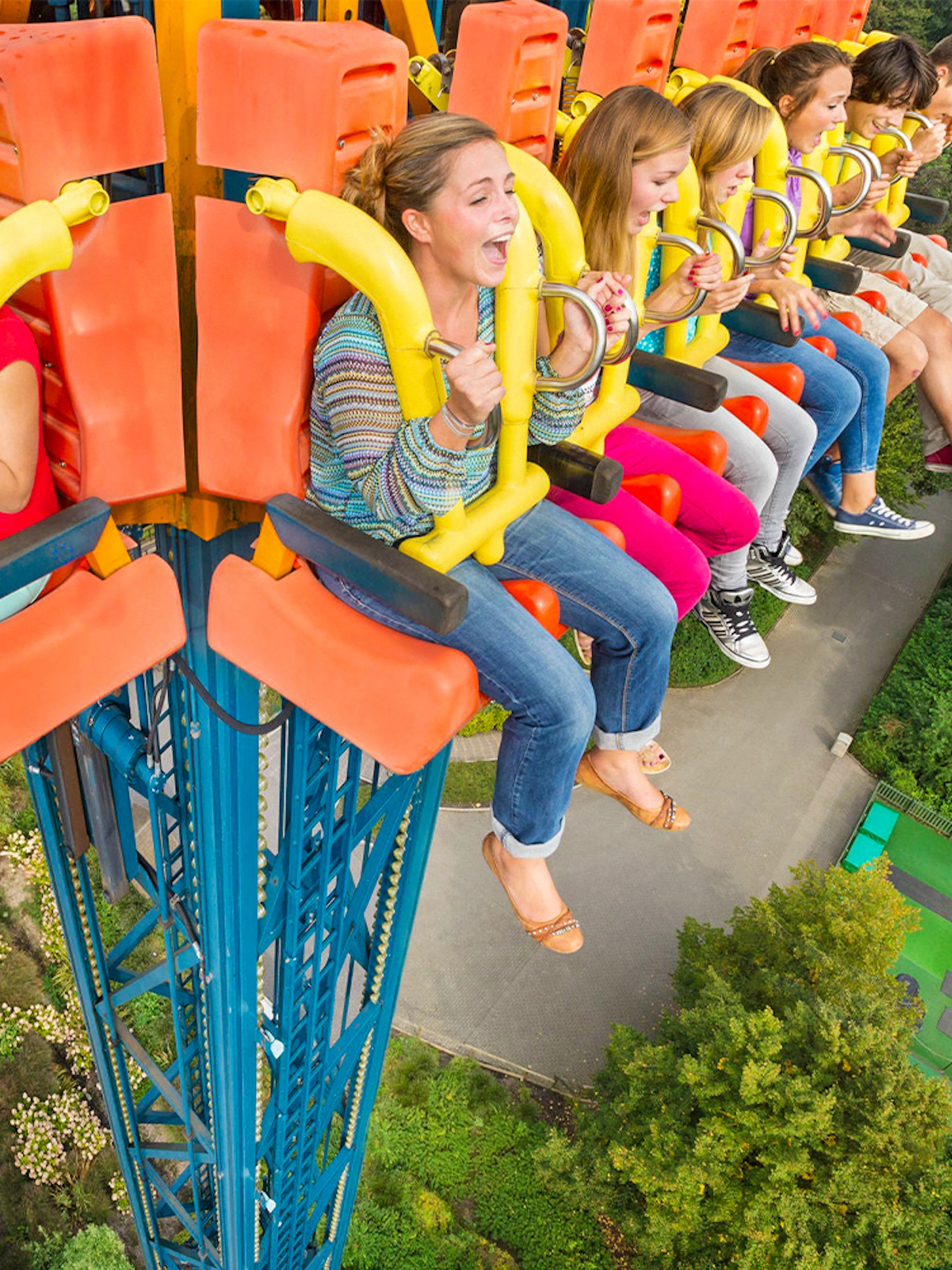 People enjoying the Screaming Eagle ride, high above a lush park landscape.