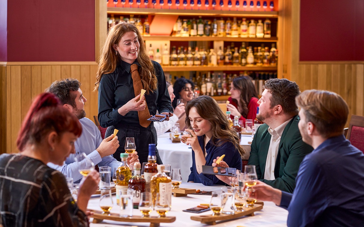 Guests enjoying whisky tasting with host at the Scotch Whisky Experience.