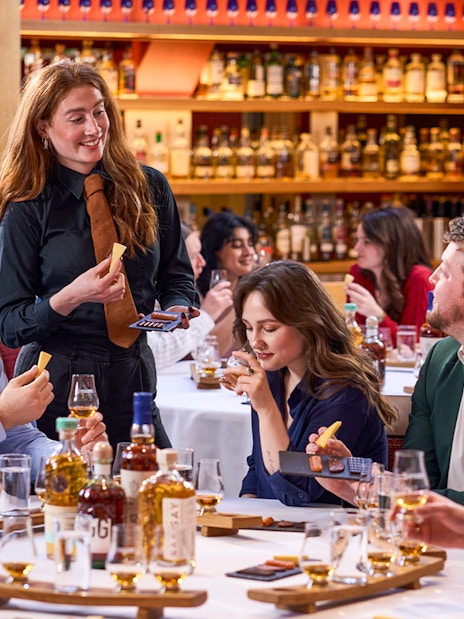 Guests enjoying whisky tasting with host at the Scotch Whisky Experience.
