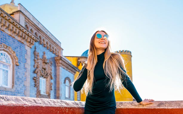 Tourist woman admires Pena National Palace in Portugal.