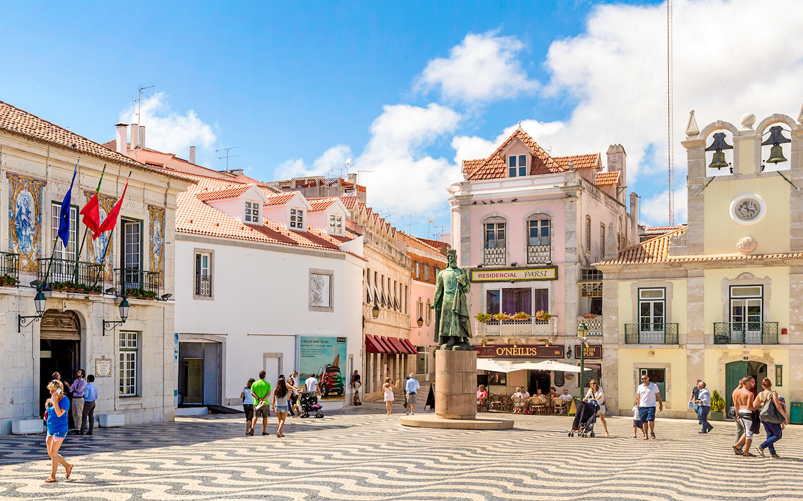 Cascais main square with statue, historic buildings, and people walking.