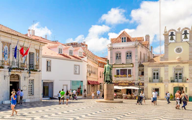 Cascais main square with statue, historic buildings, and people walking.