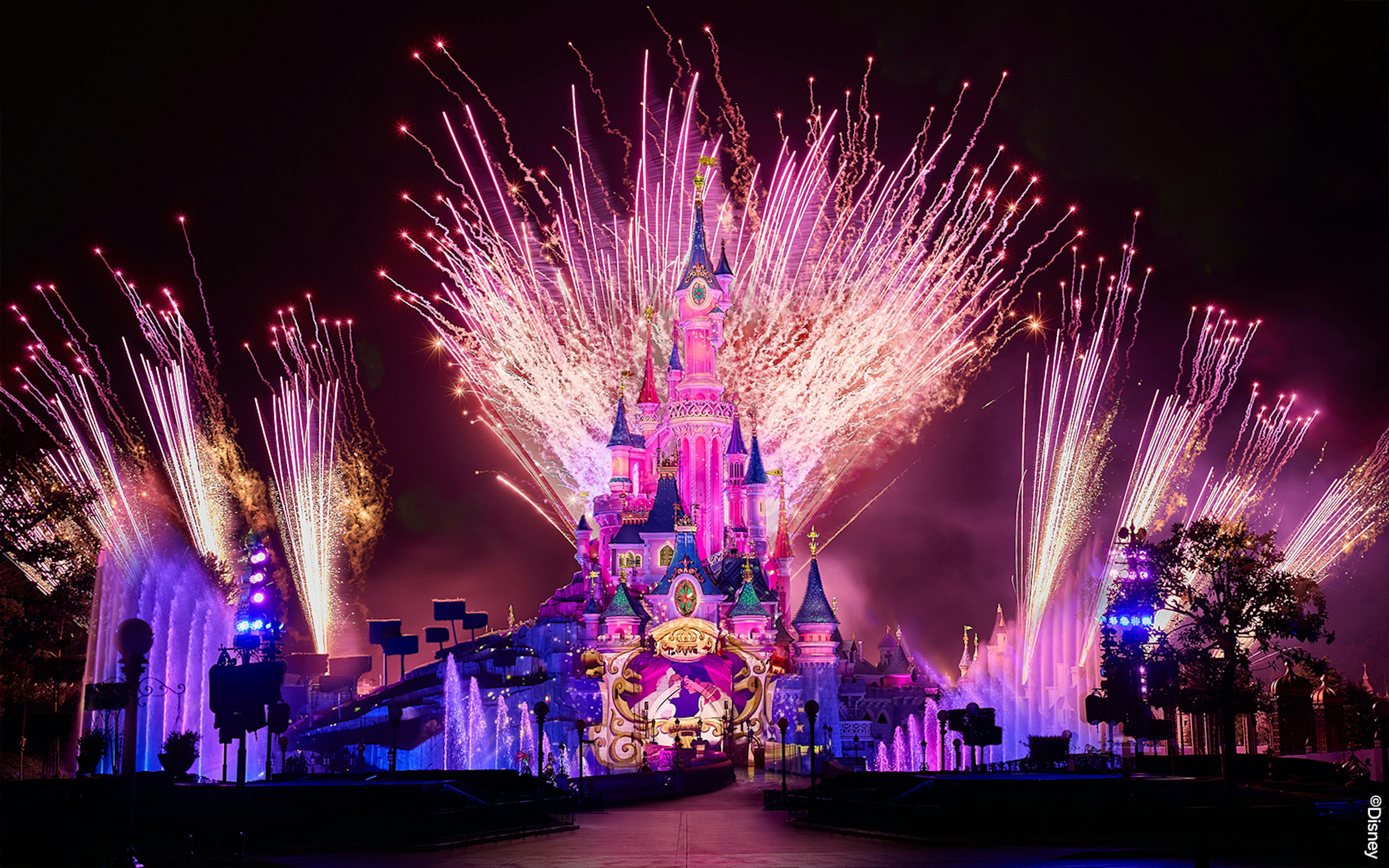 Fireworks display over Sleeping Beauty Castle during Disneyland Paris light show.