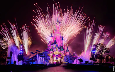 Fireworks display over Sleeping Beauty Castle during Disneyland Paris light show.