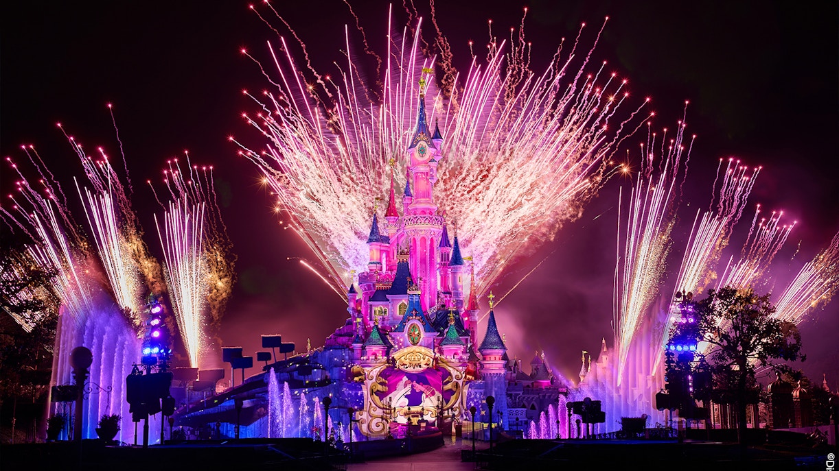 Fireworks display over Sleeping Beauty Castle during Disneyland Paris light show.