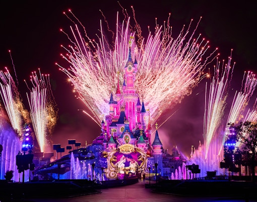Fireworks display over Sleeping Beauty Castle during Disneyland Paris light show.