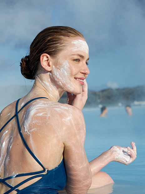 Tourist applying silica mud in Blue Lagoon, Iceland.