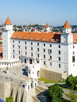Bratislava Castle with red rooftops and towers, overlooking the cityscape in Slovakia.