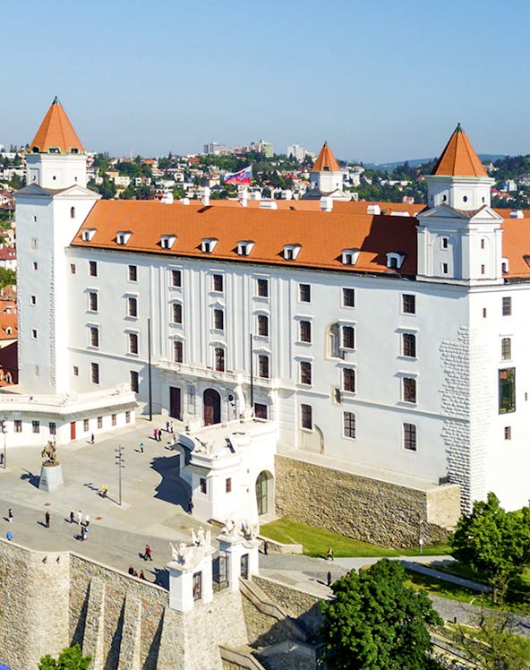 Bratislava Castle with red rooftops and towers, overlooking the cityscape in Slovakia.