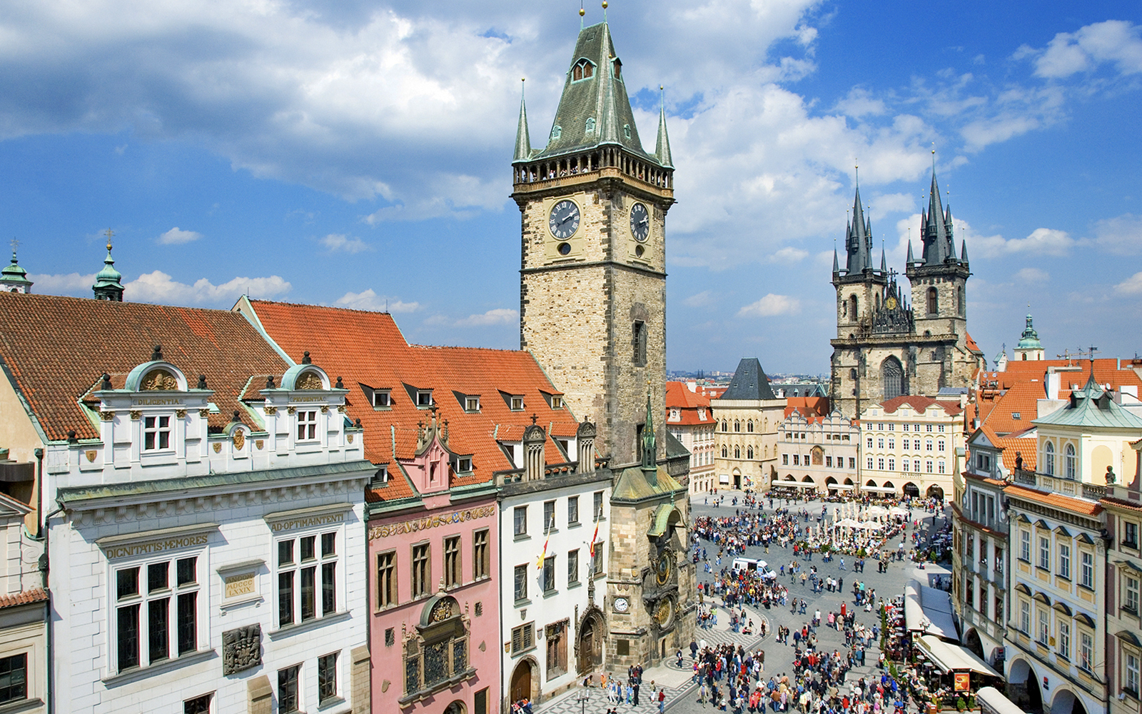 Prague Astronomical Tower overlooking a crowded square on a weekend.