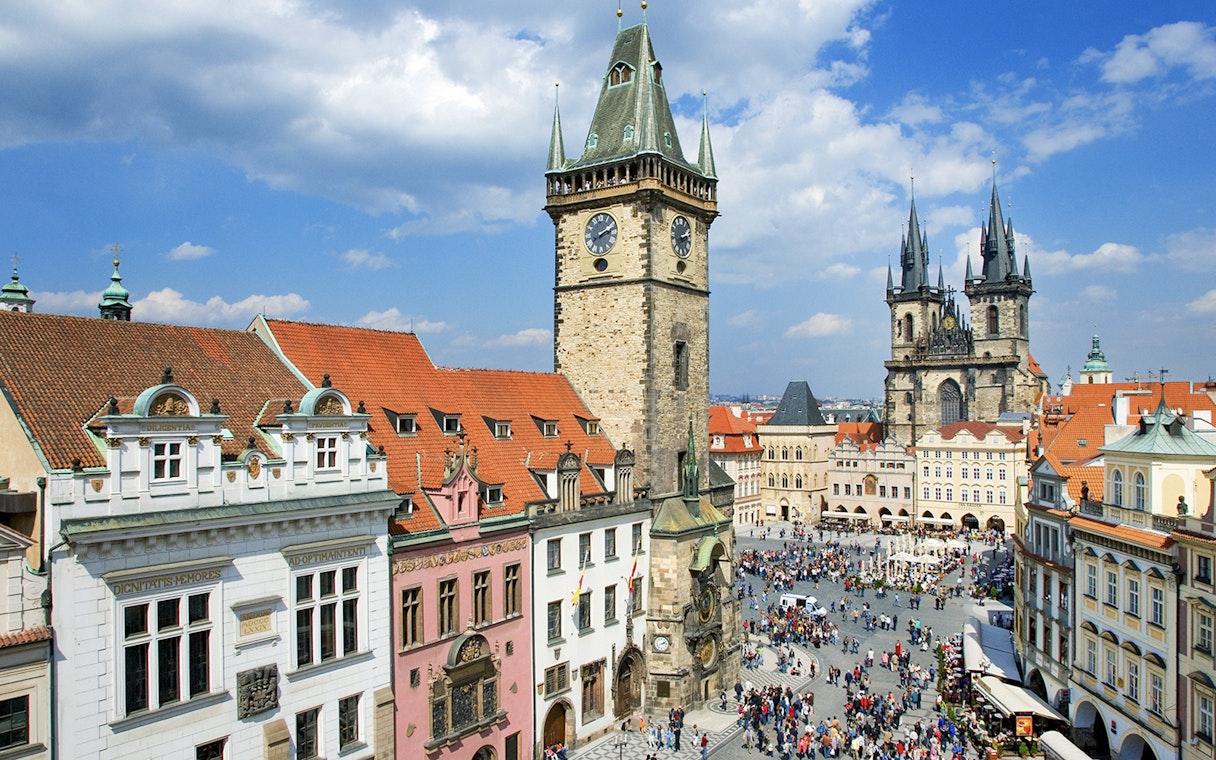 Prague Astronomical Tower overlooking a crowded square on a weekend.