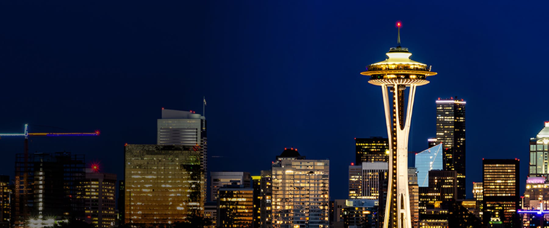 Seattle skyline at night featuring the illuminated Space Needle.