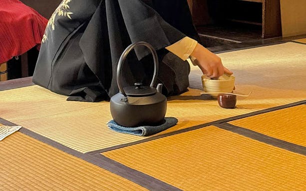 Kettle on tatami mat during traditional matcha preparation in Japan.