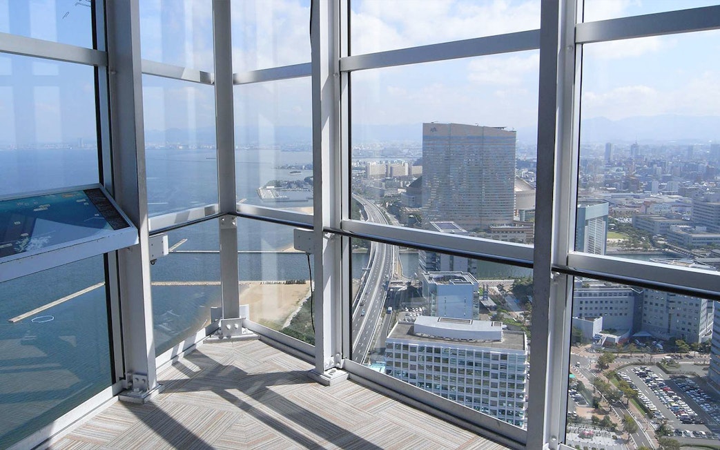 View from Fukuoka Tower observation deck overlooking cityscape and coastline.