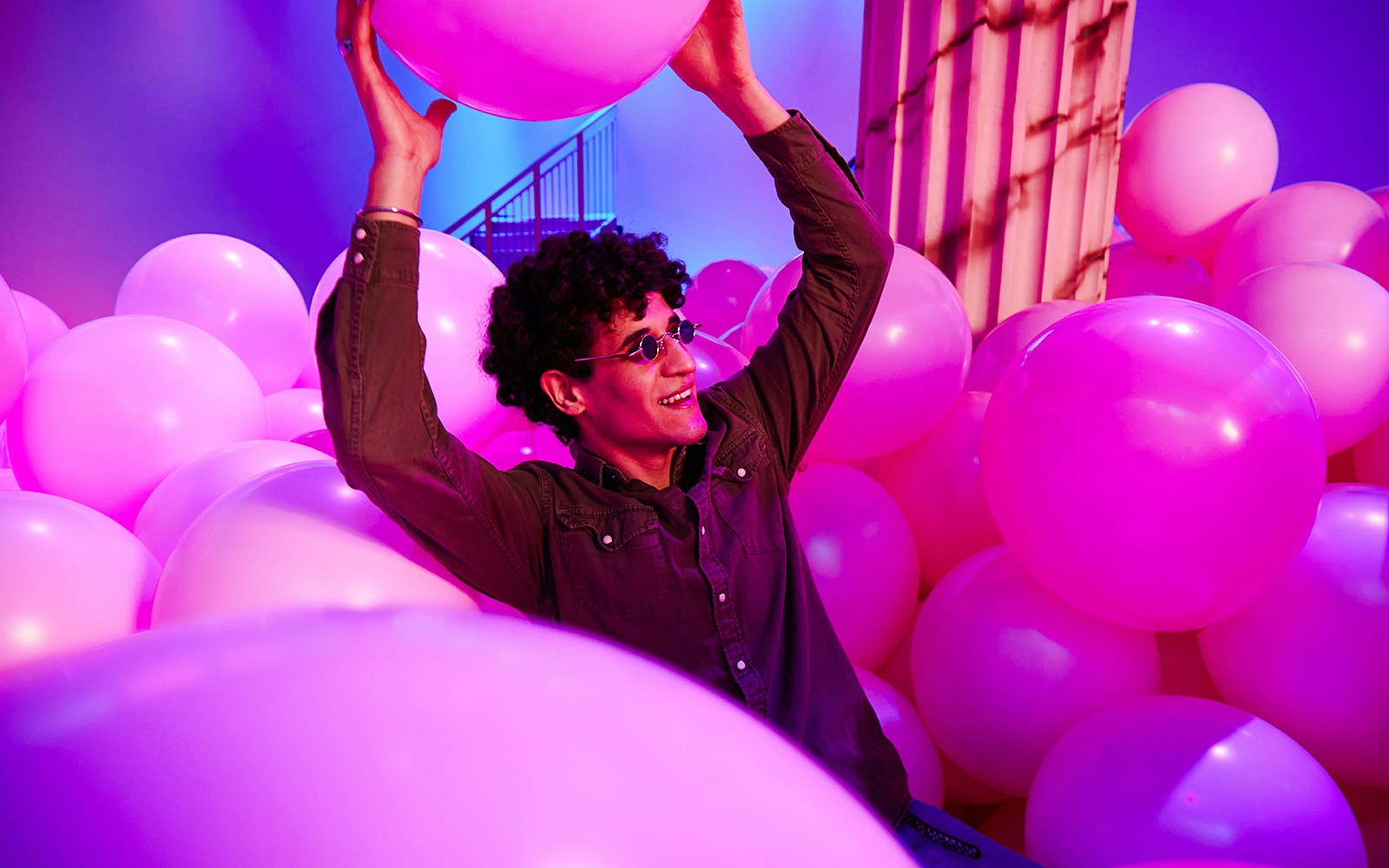 Person enjoying pink balloons at Bubble Planet exhibit, Washington DC.