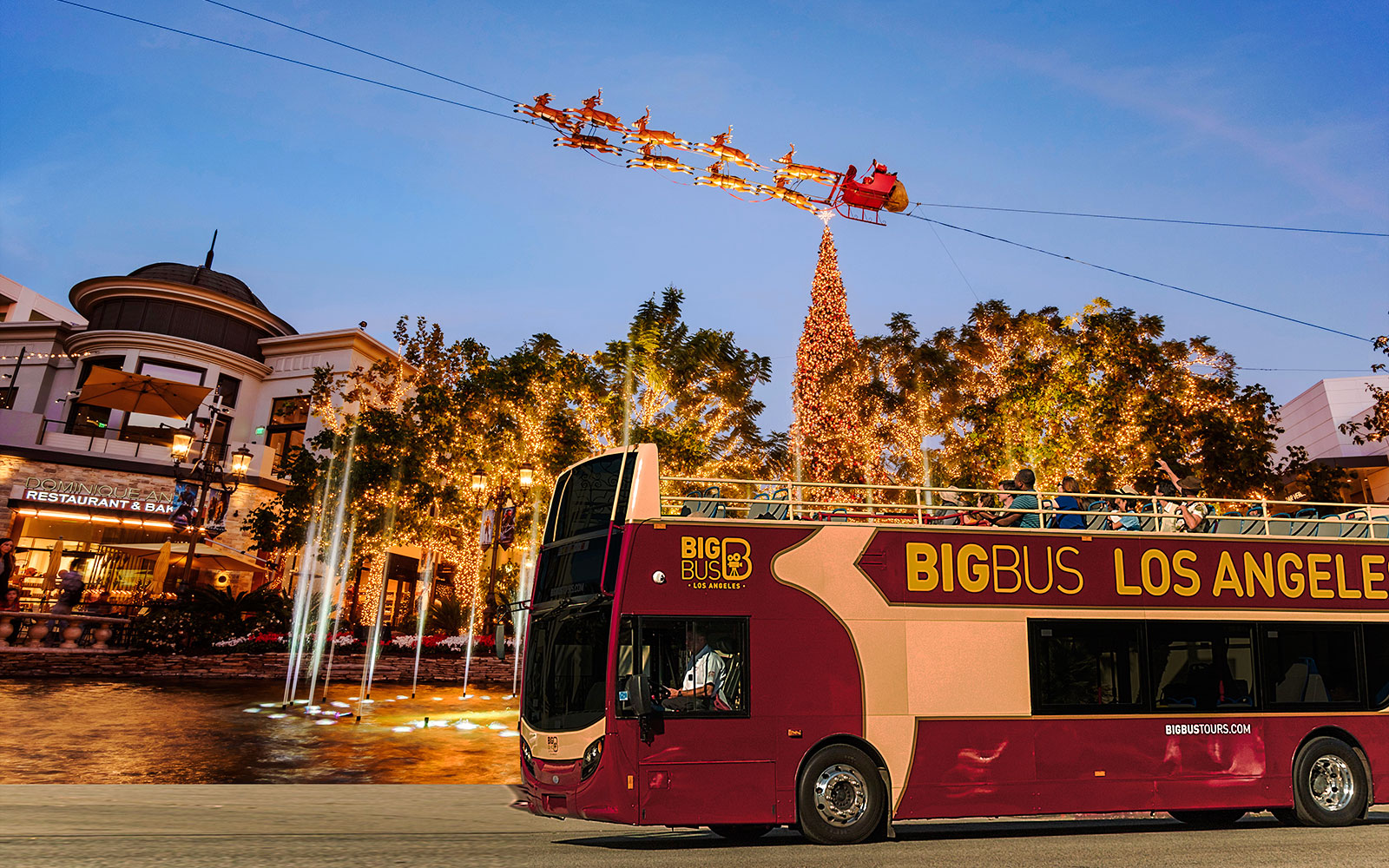 Open-top tour bus passing Christmas lights and decorations at the Grove, Los Angeles.