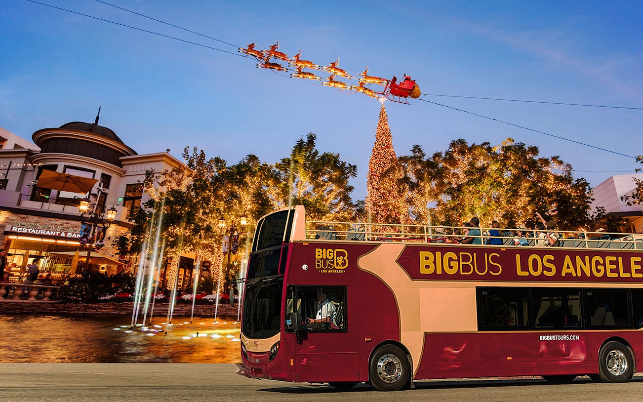 Open-top tour bus passing Christmas lights and decorations at the Grove, Los Angeles.