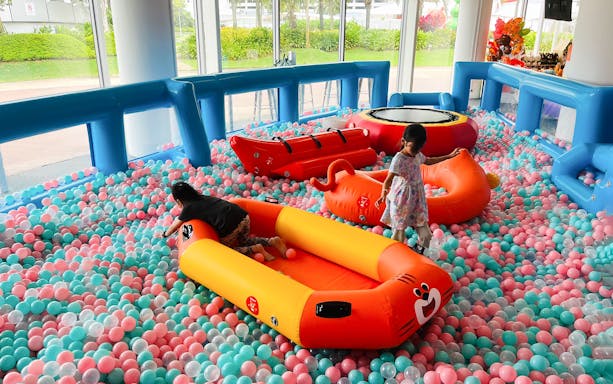 Children playing on inflatable boats in a colorful ball pit at Bouncetopia by Kiztopia, VivoCity.