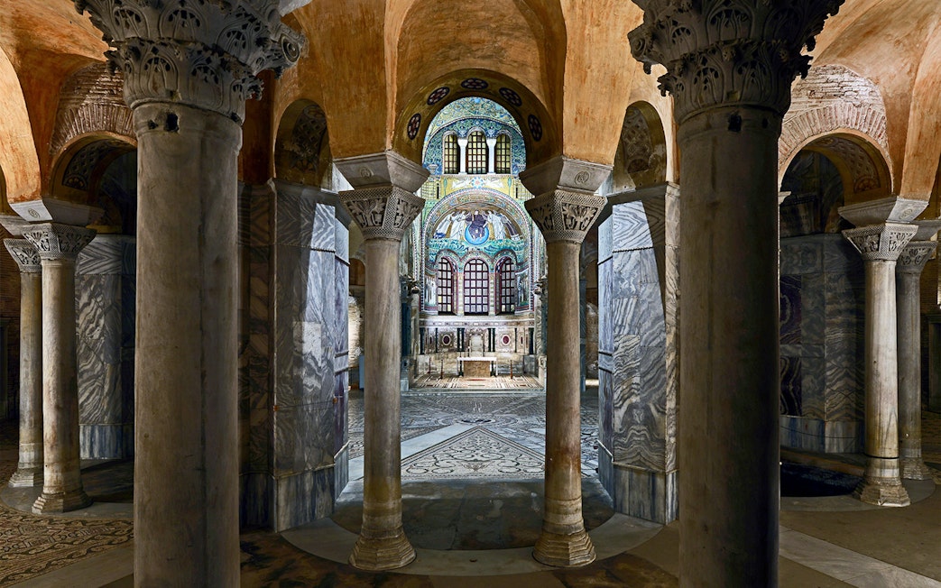 Ravenna Basilica interior with ornate columns and detailed mosaic ceiling.