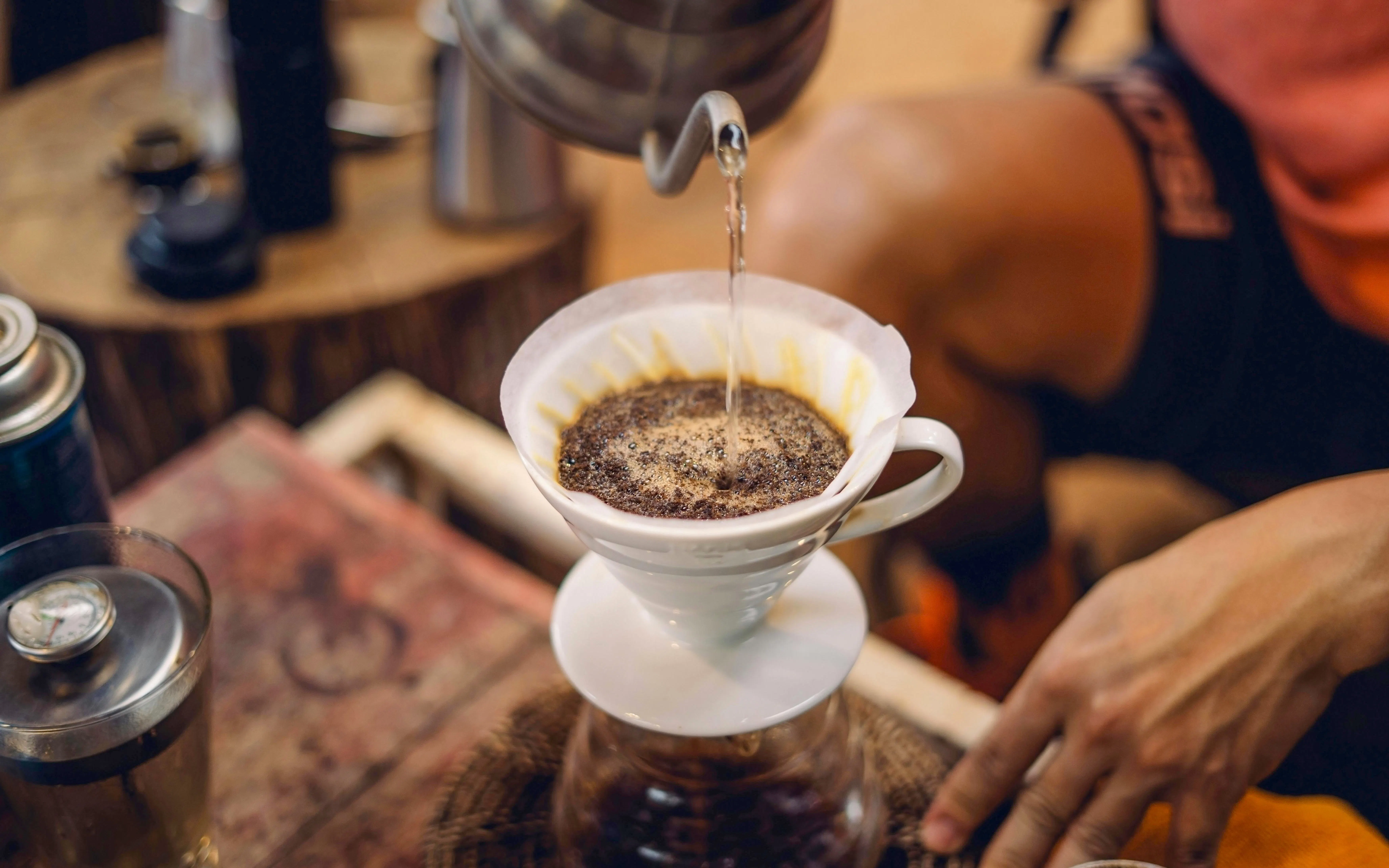 Pouring hot water over ground coffee in a filter for brewing.