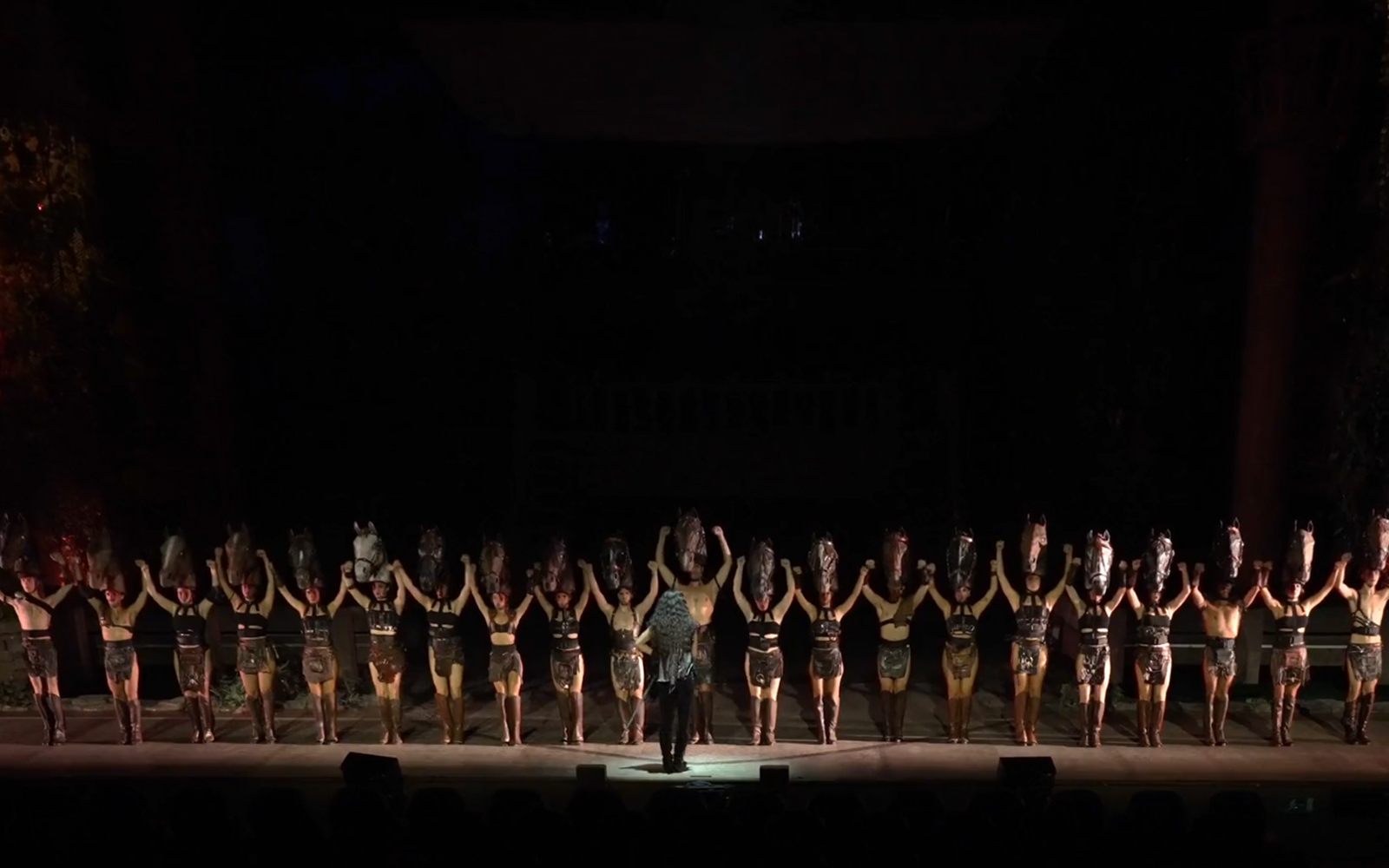 Performers on stage during "MALINCHE, un musical de Nacho Cano" with horse head costumes.