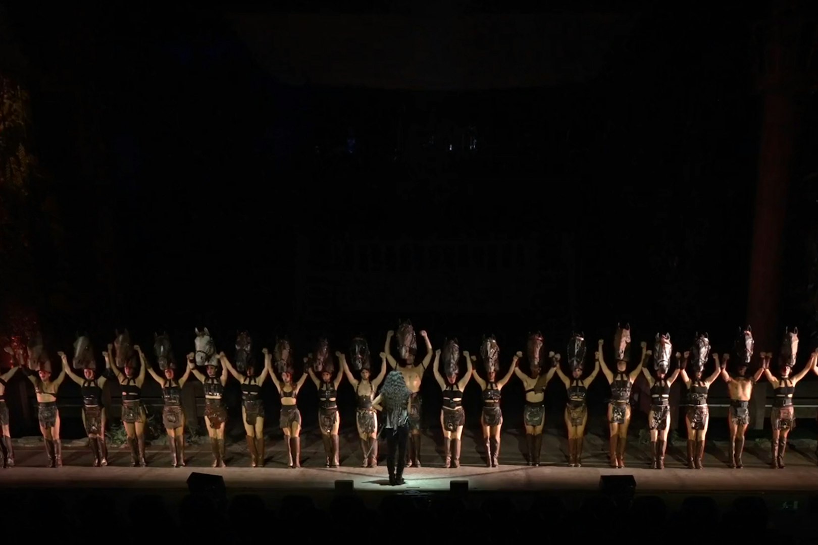 Performers on stage during "MALINCHE, un musical de Nacho Cano" with horse head costumes.